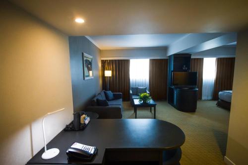 a hotel room with a desk and a living room at Crowne Plaza Managua by IHG in Managua