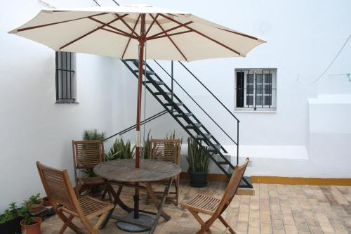a table and chairs with an umbrella and a staircase at Pensión España in Cádiz