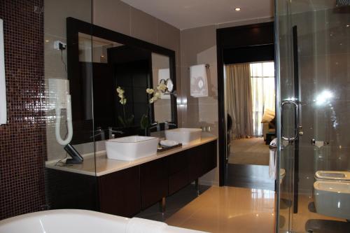 bagno con 2 lavandini e doccia di Donatello Boutique Hotel a Almaty