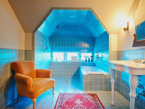 聖安東尼奧的住宿－哈瓦那酒店，蓝色的浴室设有浴缸、椅子和水槽