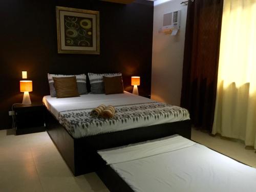 a bedroom with a bed and two lamps and a bed sidx sidx sidx at Casita Isla Beach Inn in Boracay