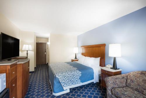 a hotel room with a bed and a flat screen tv at Aderi Hotel Near Casino in Niantic