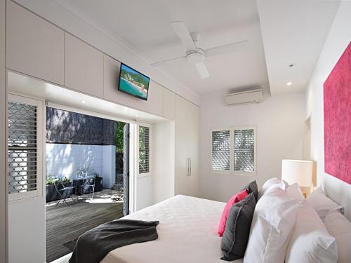 a bedroom with a bed and a tv on the wall at Allambi in Noosa Heads