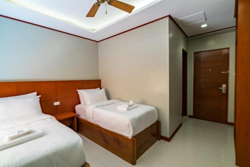 a bedroom with two beds and a ceiling fan at Coral Cliff Hotel in El Nido