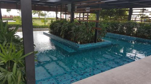 a swimming pool with plants in a building at Zen Studio @ Trefoil Setia Alam in Shah Alam