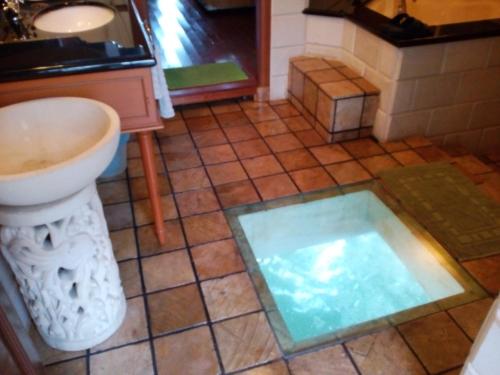 a bathroom with a sink and a toilet and a tub at Wonderland Private Chalet at Port Dickson in Port Dickson