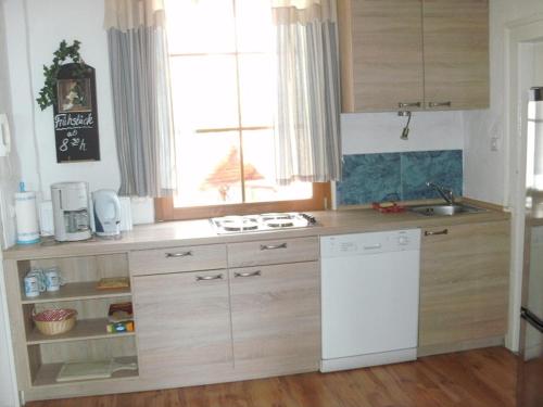 a kitchen with a white refrigerator and a window at Gästehaus zum Felsen in Überlingen