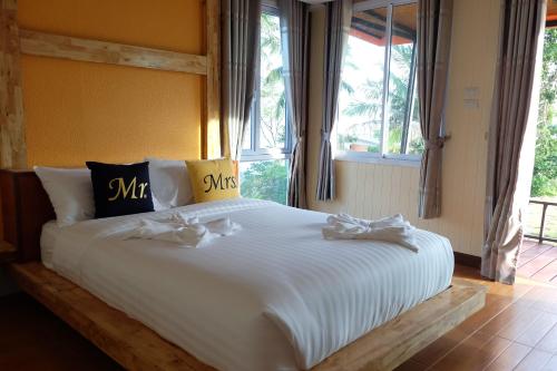 a bedroom with a large white bed with windows at Love Koh Tao Villa in Koh Tao