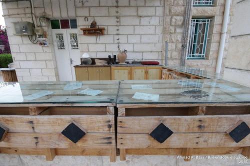 Auberg-Inn Guesthouse في أريحا: طاولة خشبية كبيرة مع غطاء زجاجي
