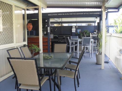 a patio with a table and chairs on a porch at Beachlander Self-Contained Holiday Apartments in Coffs Harbour