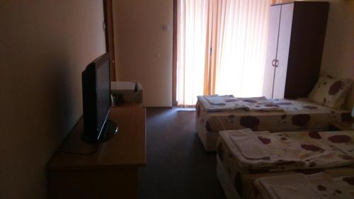 a room with two beds and a flat screen tv at Guest House Pri Valyo in Primorsko