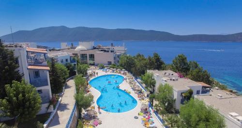 an overhead view of a large swimming pool next to the water at Bodrum Holiday Resort & Spa in Bodrum City