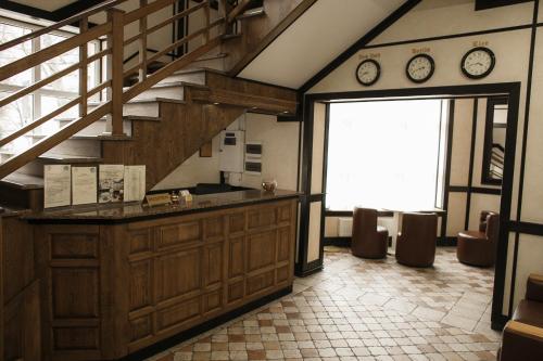 a kitchen with a counter and a staircase with clocks at Georg Palace Hotel in Chernivtsi