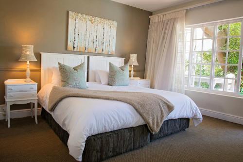 Un dormitorio con una cama grande y una ventana en First Avenue Guesthouse, en Port Elizabeth