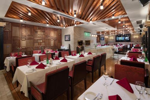 a restaurant with white tables and red napkins at Silk Path Hotel Hanoi in Hanoi
