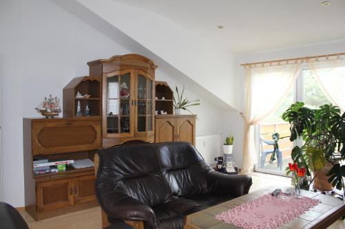 a living room with a leather couch and a table at Ferienwohnungen Sansibar in Kasnevitz