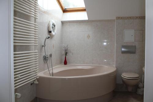 a bathroom with a large tub and a toilet at Ferienwohnungen Sansibar in Kasnevitz