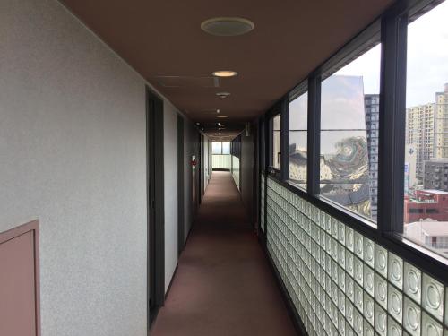 an empty hallway in an office building with windows at Hotel 21 in Kusatsu