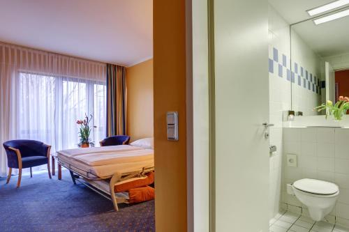 a hospital room with a bed and a bathroom at Centro Park Hotel Berlin-Neukölln in Berlin
