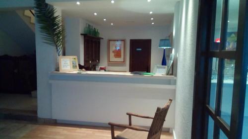 a restaurant with a counter and a chair at Galaxia Boutique Hotel in Can Picafort