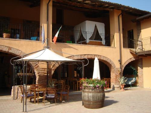 a patio with a table and an umbrella in front of a building at Agriturismo SANGALLO in bedizzol