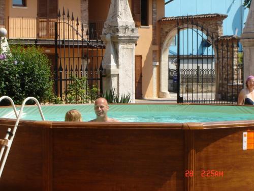 a man in a jacuzzi in a swimming pool at Agriturismo SANGALLO in bedizzol