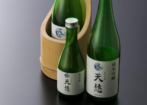 two green bottles of wine sitting next to a barrel at Hakone Kowakien Tenyu in Hakone