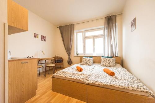 1 dormitorio con 1 cama con almohadas de color naranja en Apartments Presidential Palace en Bratislava