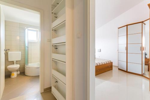 a bathroom with a toilet and a walk in closet at Apartments Gloria in Ližnjan