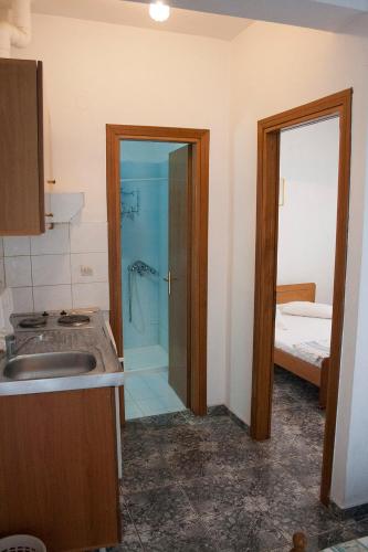 a bathroom with a shower with a sink and a sink at Peristerianos apartments in Nea Skioni