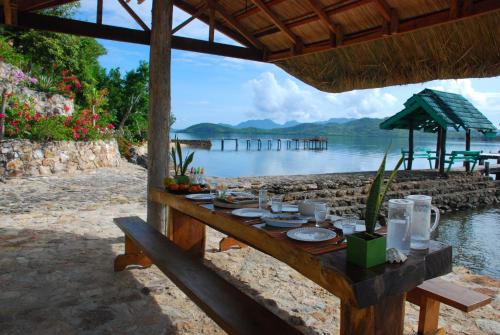 a table with food on it next to a body of water at La Estancia Busuanga in Busuanga