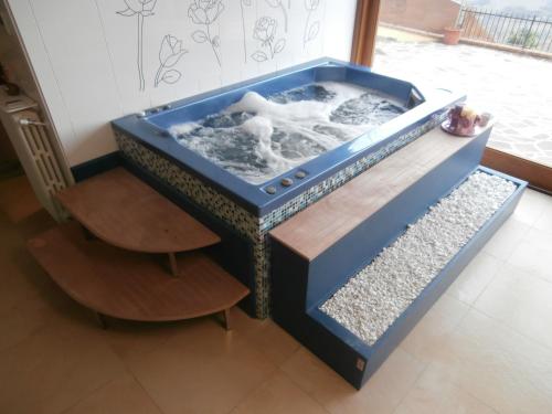 a blue aquarium with a wooden table and two chairs at Albergo Diffuso - Il Poggetto tra Urbino & San Marino in Urbino