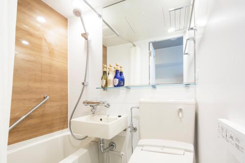 HOTEL MYSTAYS Gotanda في طوكيو: حمام مع حوض ومرحاض وحوض استحمام