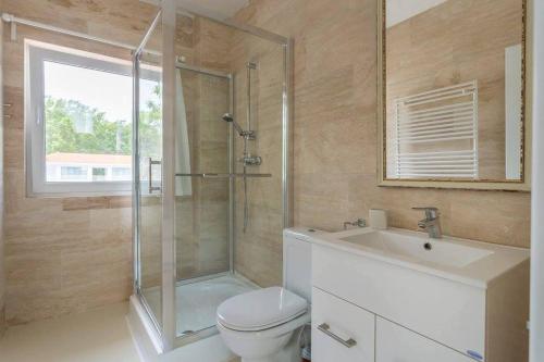 a bathroom with a shower and a toilet and a sink at Casa De Mare in Olimp