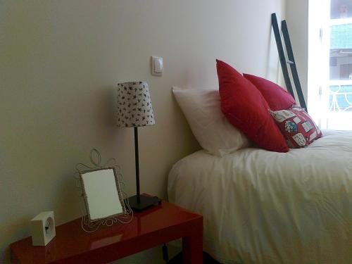 a bedroom with a bed, desk and lamp at Formosa Oporto Apartments Group in Porto