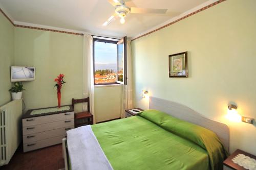 a bedroom with a green bed and a window at Casabb in Toscolano Maderno