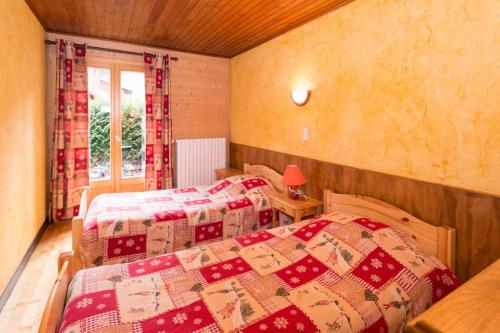 1 dormitorio con 2 camas y edredón en Le Petit Chalet, en Morzine