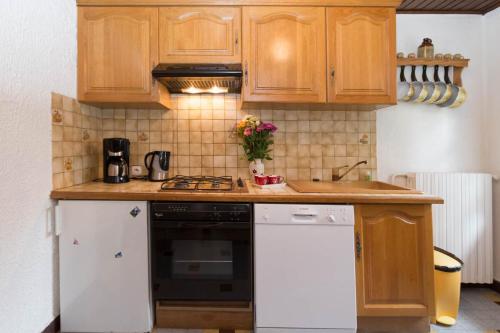 a kitchen with wooden cabinets and a stove top oven at Le Petit Chalet in Morzine