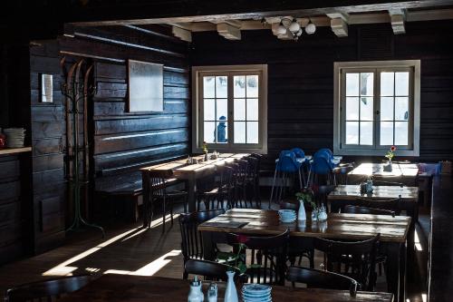 a restaurant with wooden walls and tables and windows at Prezidentská in Bedřichov