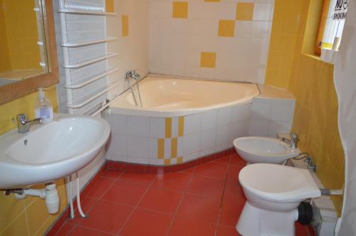 y baño con bañera, aseo y lavamanos. en Hostel 66, en Szeged
