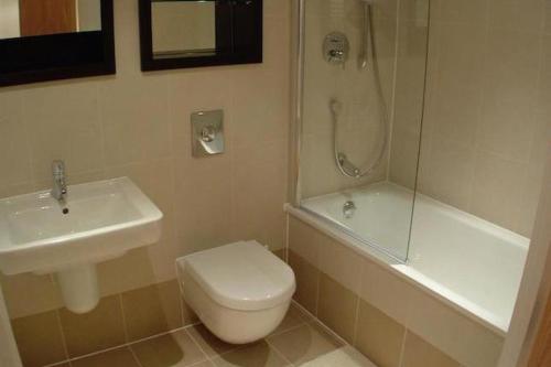 a bathroom with a sink and a toilet and a shower at Leeds City Centre Apartments in Leeds