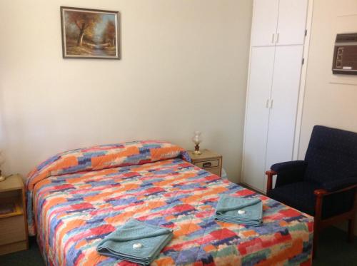 a bedroom with a bed with two bags on it at Murray Bridge Motor Inn in Murray Bridge