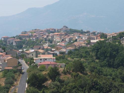 a village on a hill with a mountain in the background at Appartamento Perito in Perito