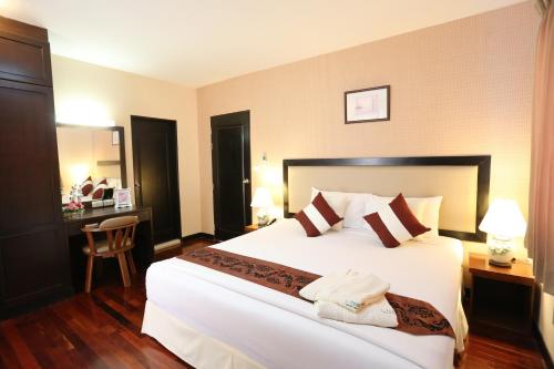 a bedroom with a large white bed in a room at J Town Serviced Apartments & Hotel in Si Racha