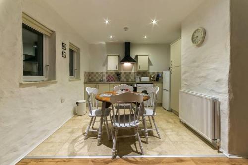 uma cozinha e sala de jantar com mesa e cadeiras em Ballymultimber Cottages em Limavady