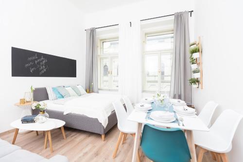 uma sala de estar branca com um sofá e uma mesa em Chill apartments em Praga