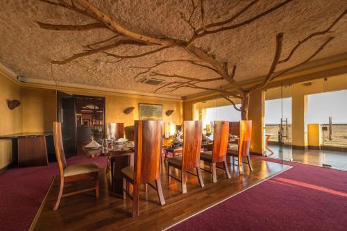 a dining room with a table and a tree ceiling at Ole Sereni in Nairobi