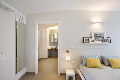 a white living room with a bed and a table at MelRose Relais in Massa Lubrense