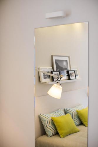 a mirror above a couch with two pillows at MelRose Relais in Massa Lubrense