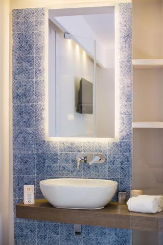 a bathroom with a white sink and a mirror at MelRose Relais in Massa Lubrense